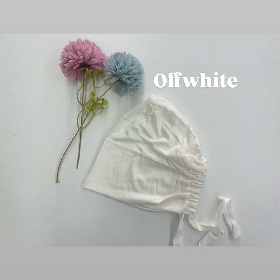 White baby bonnet with pink and blue flowers on a light gray background, featuring the brand 'Offwhite'.